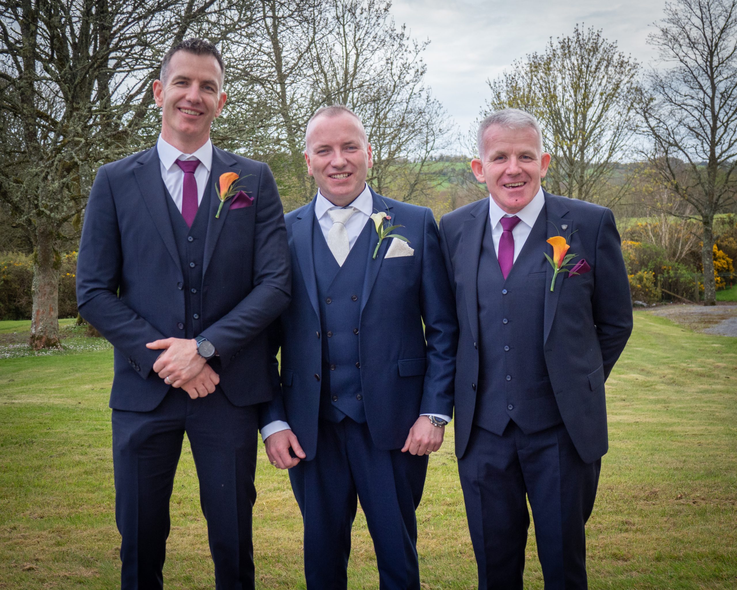 Best Man, Groom, and Groom's Dad stand for a photo in their wedding finery.