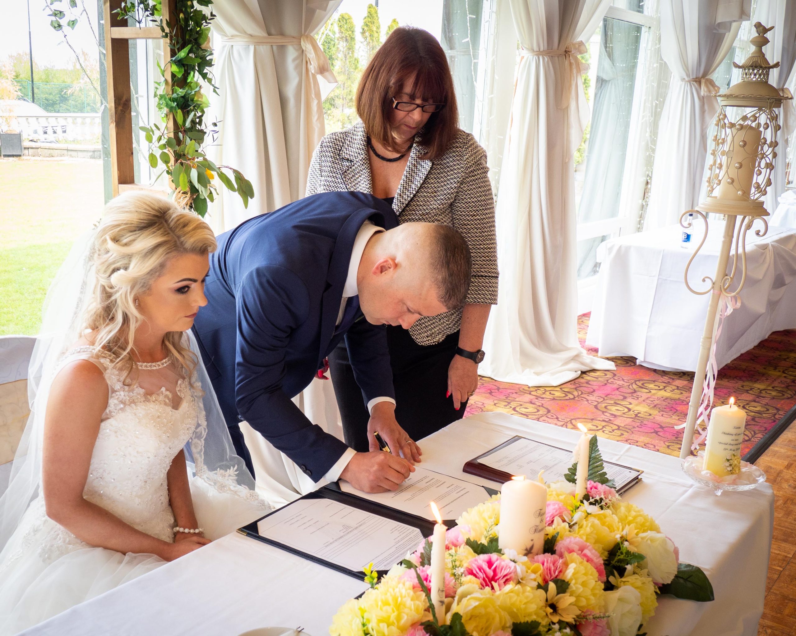The Bride & Groom sign the Wedding register admidst the wedding festivities.